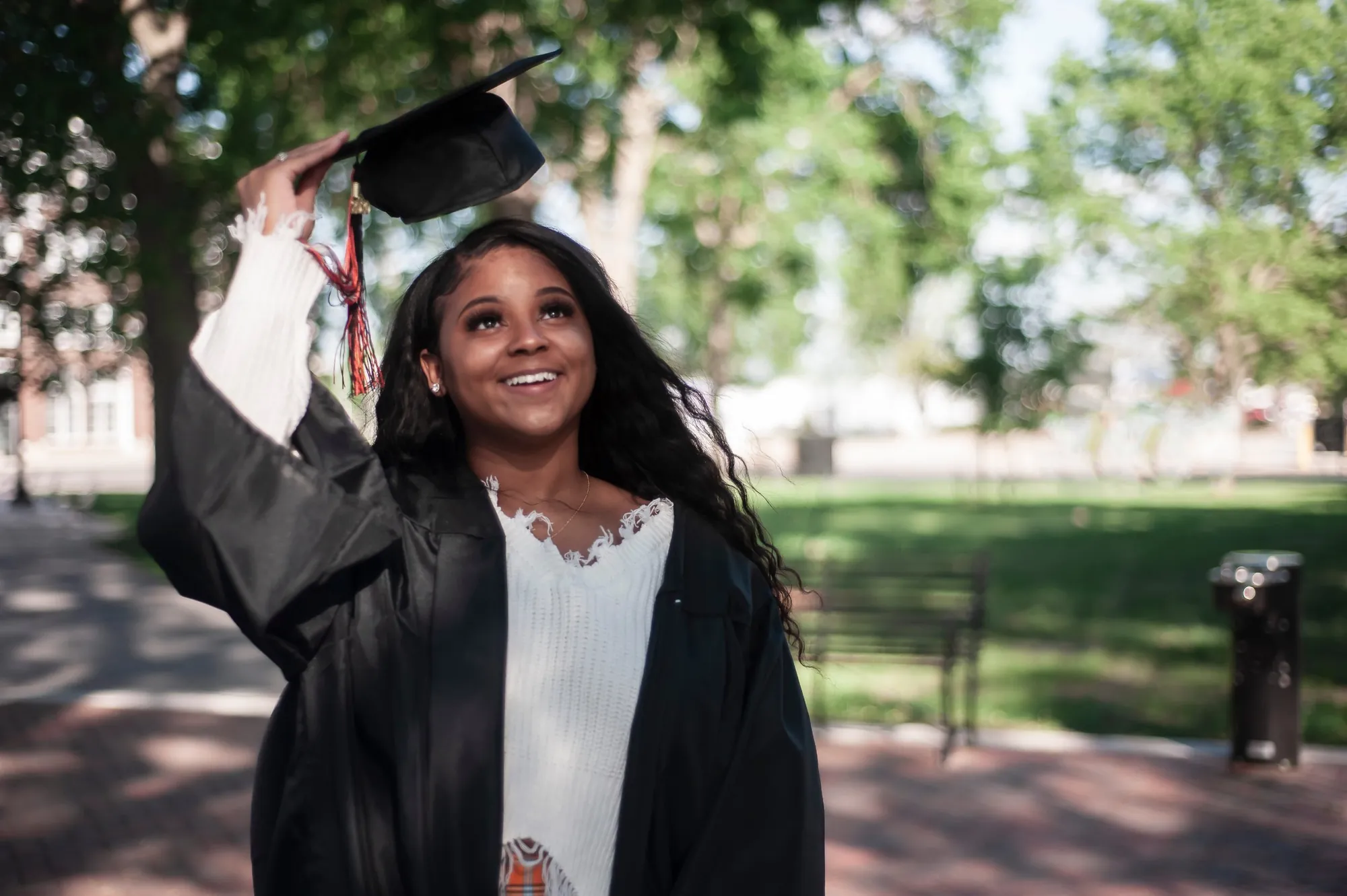 Cap and gown photos in the Cedar Valley, graduate smiling in the park