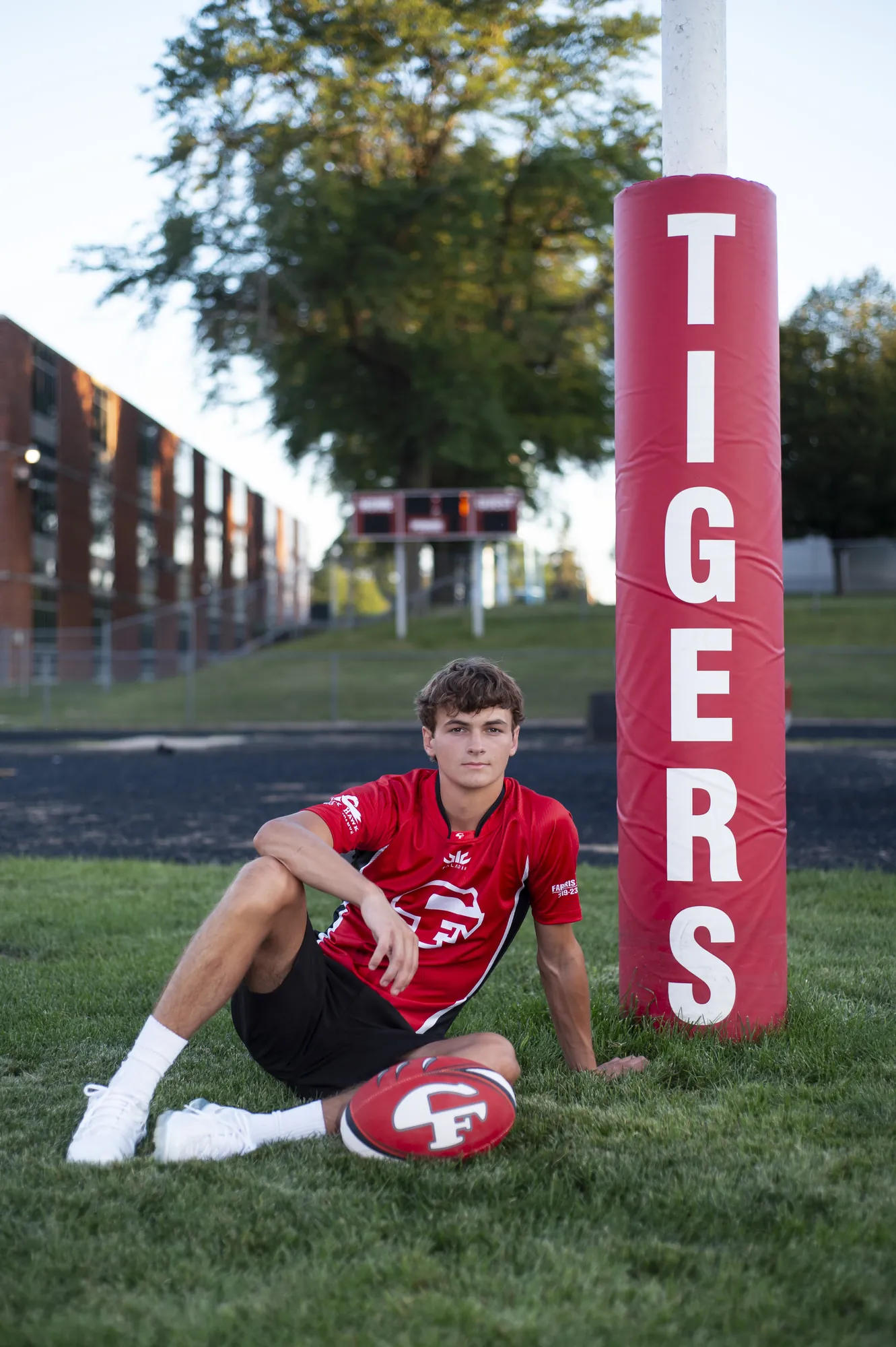 Senior pictures in Cedar Falls, football player on the Tigers field