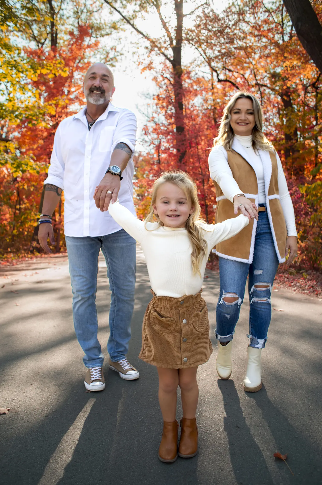 Fall family photos in the Cedar Valley, family walking under bright fall leaves
