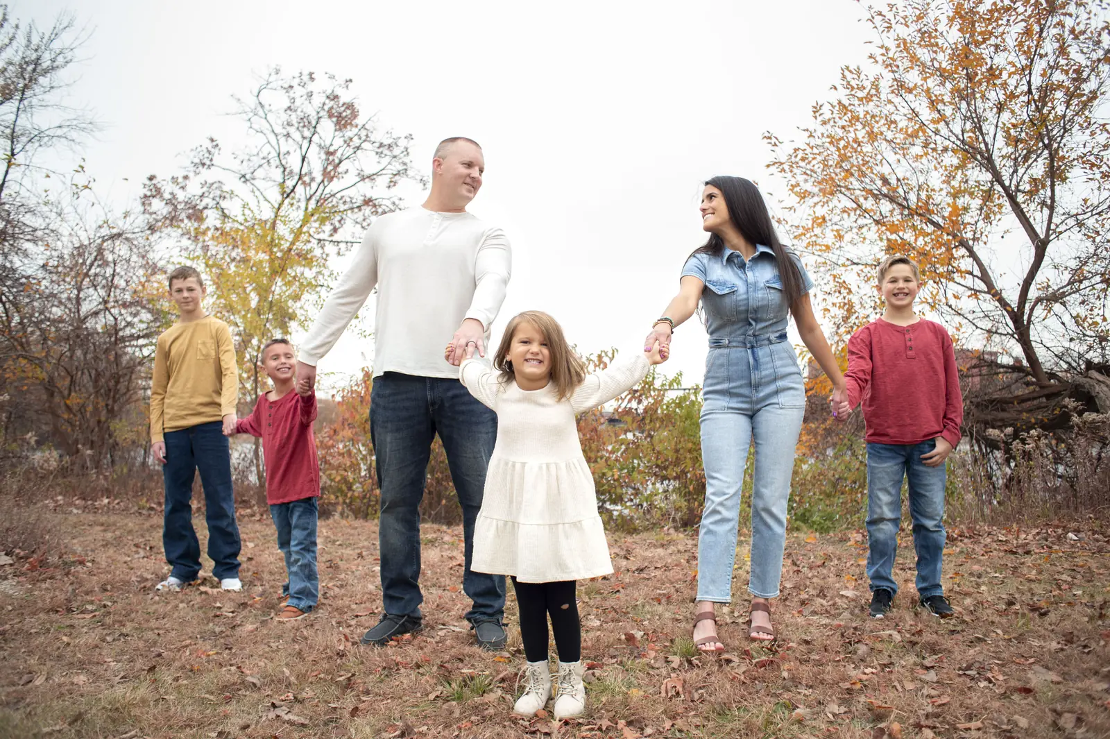 Fall family photos in the Cedar Valley, family of six in coordinated outfits holding hands