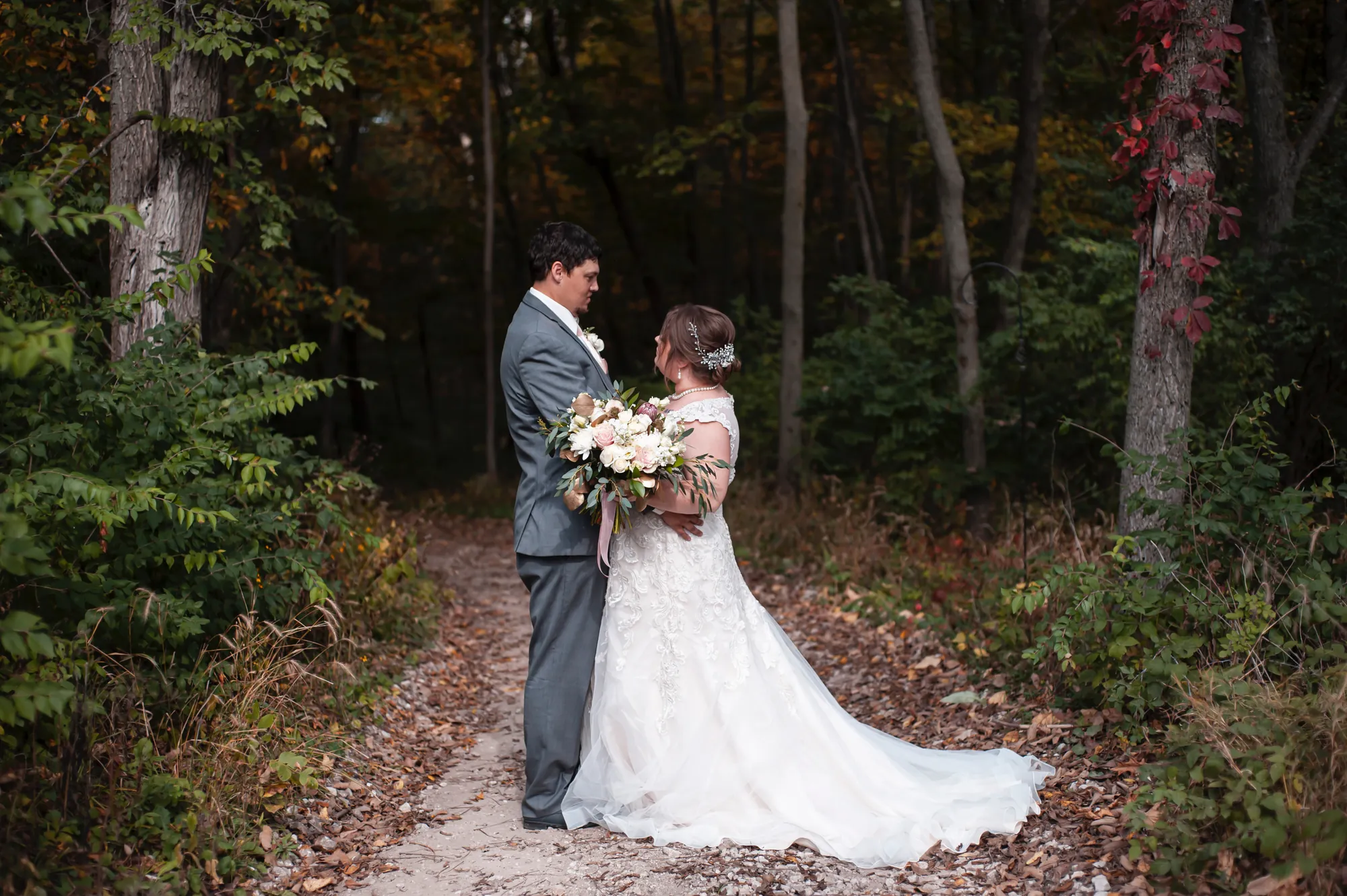Fall wedding photography in the Cedar Valley, bride and groom on a wooded path