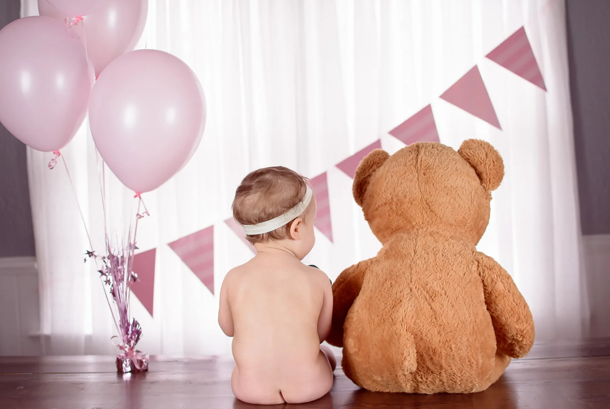 First birthday photos in the Cedar Valley, baby and teddy bear with pink balloons