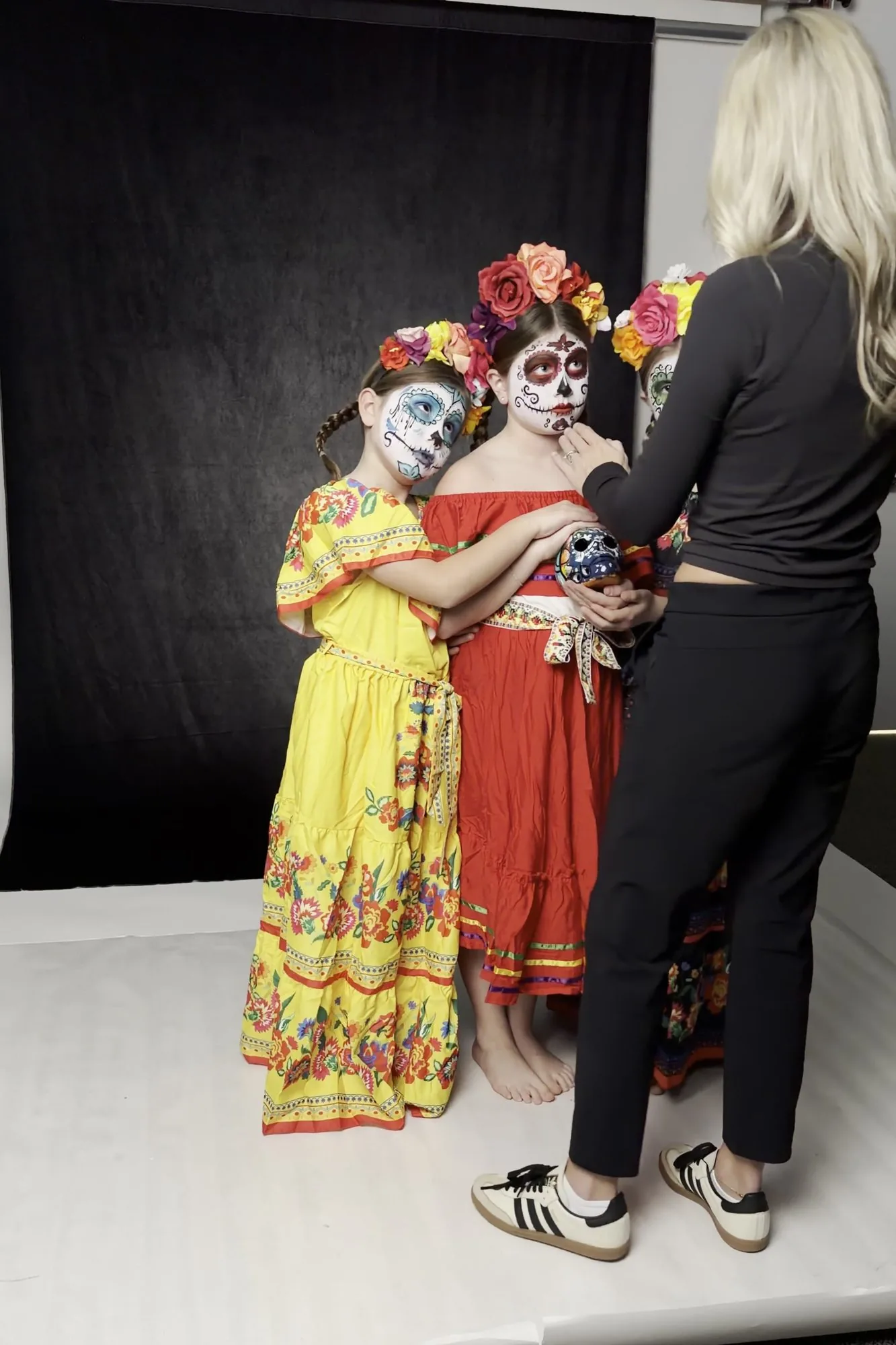 Photographer Katie McBride posing three girls in Halloween costumes in her Cedar Falls studio