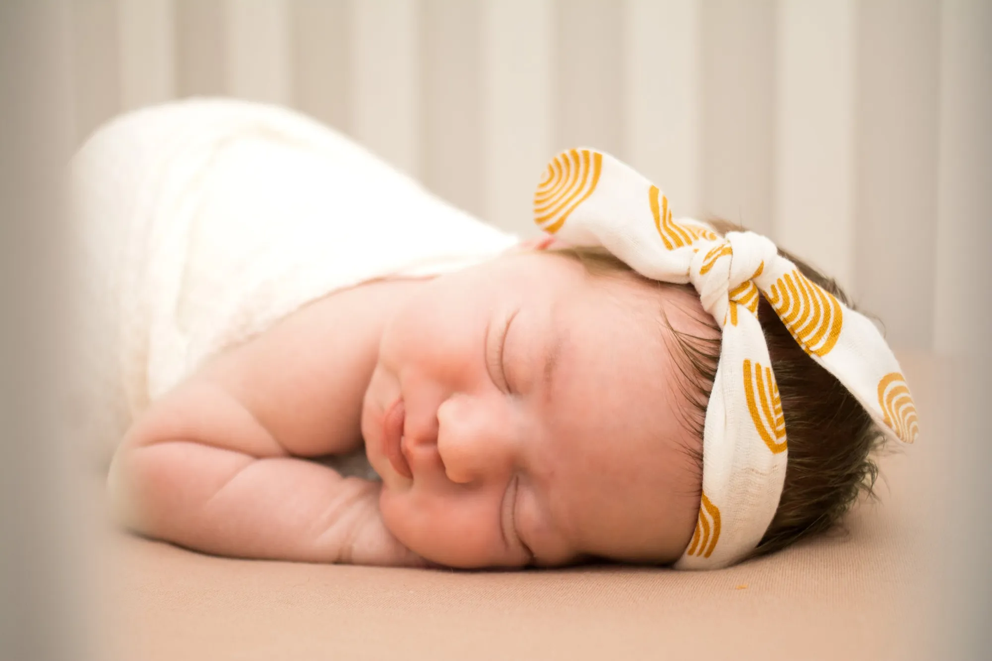 Newborn photos in the Cedar Valley, sleeping baby with a mustard bow headband