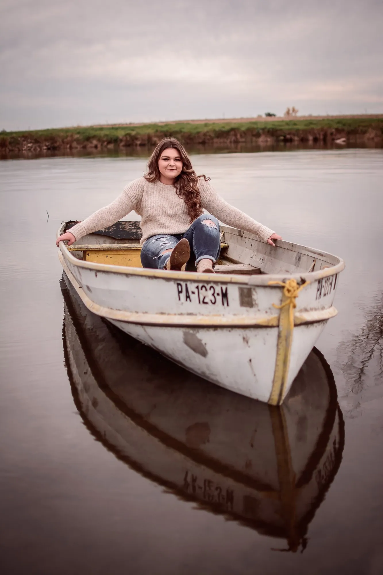 Senior pictures in a rowboat on a lake in Iowa.