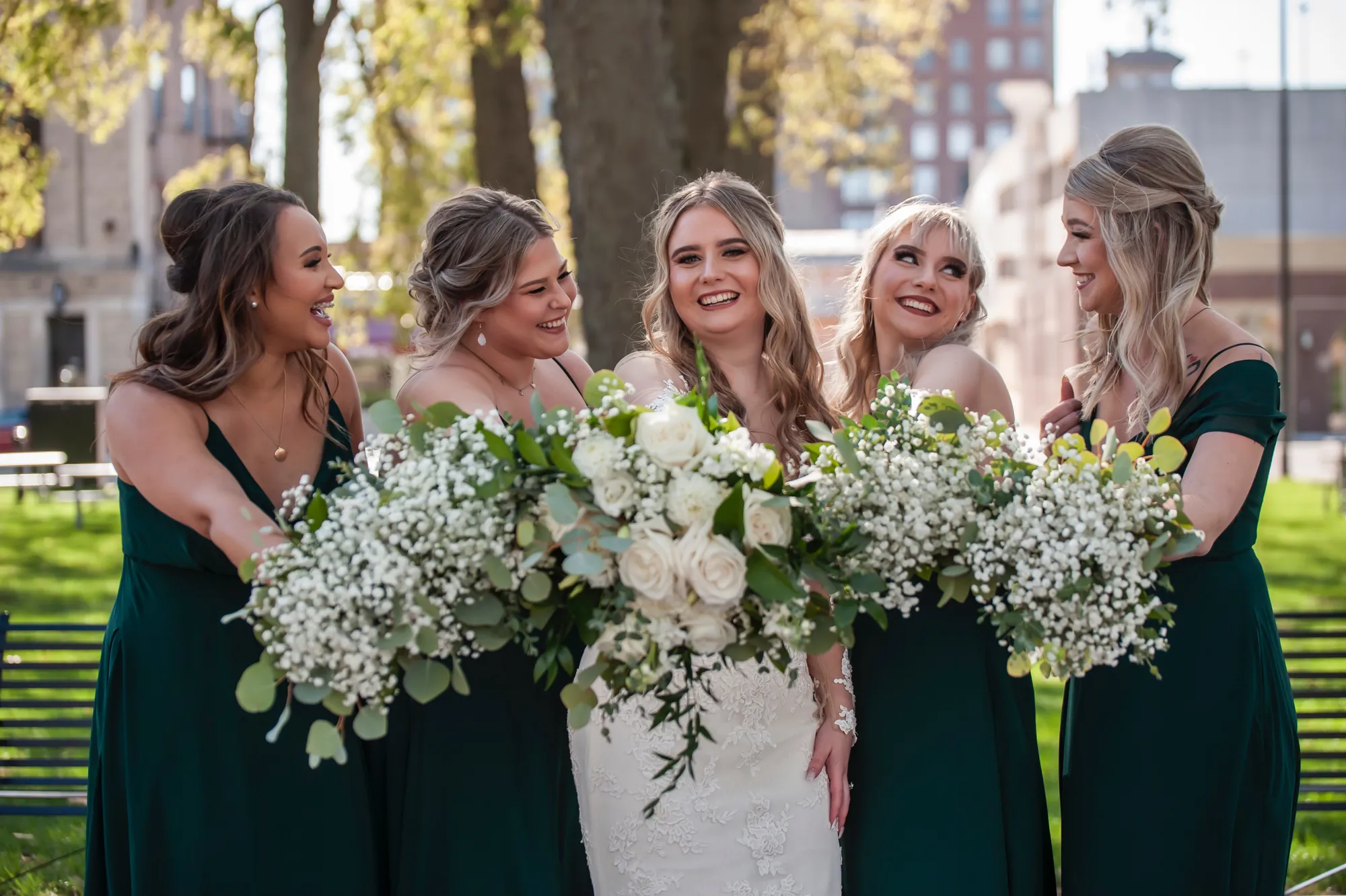 Wedding photography in Waterloo, bride and bridesmaids laughing with their bouquets