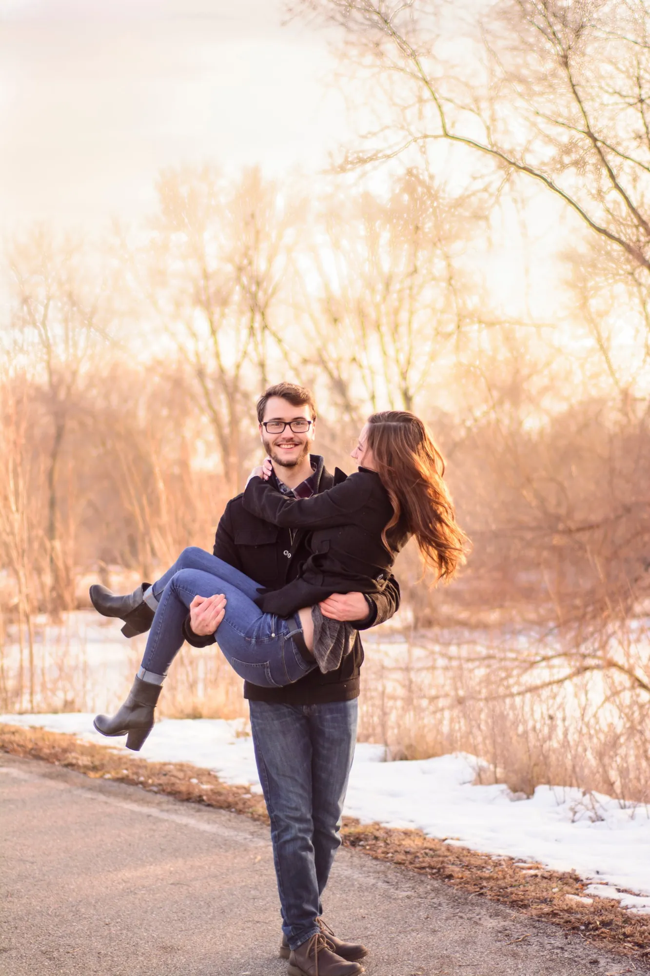 Winter engagement photos in the Cedar Valley, a playful carry at golden hour