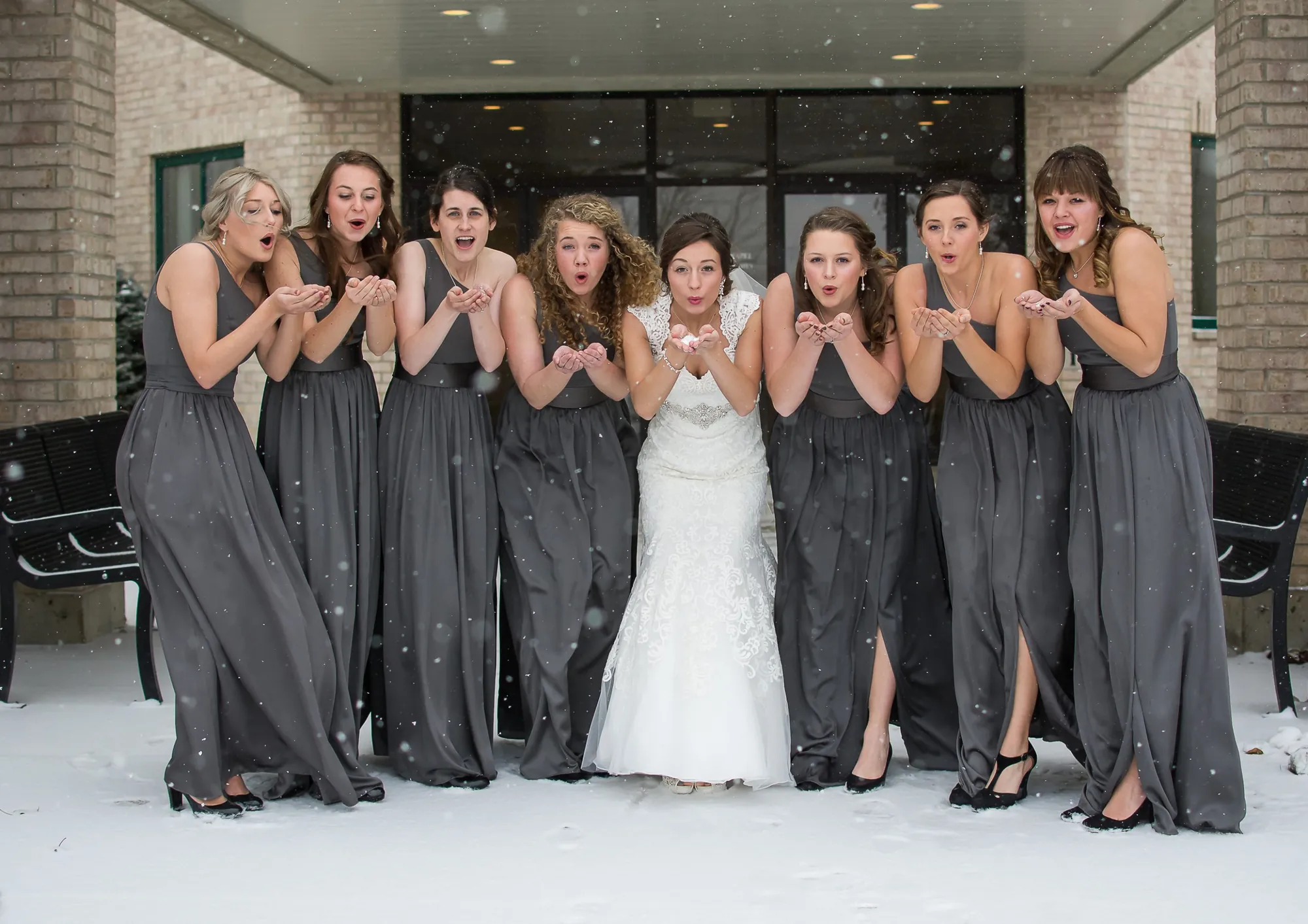 Winter wedding photography in the Cedar Valley, bride and bridesmaids blowing snow